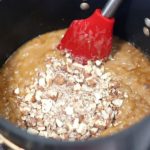 Almond being added to caramel for candy