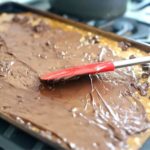 Chocolate being spread of almond Roca.