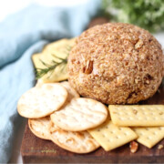 Blue Cheese and Pecan Cheese Ball on a cutting board with crackers.