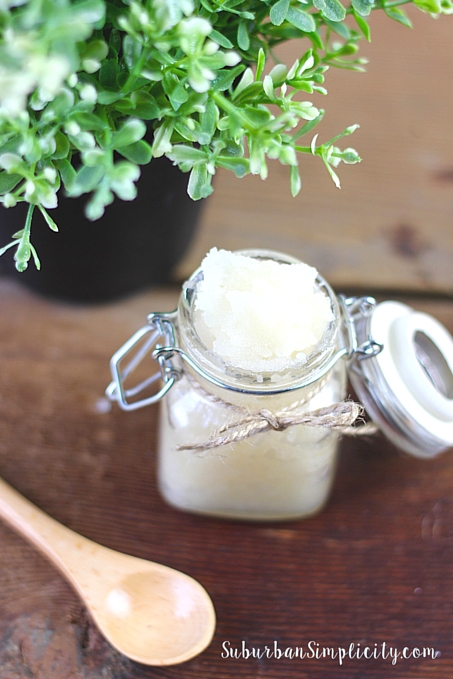 Lavender Vanilla Sugar Scrub sitting in a bottle with the lid open and a spoon next to it.