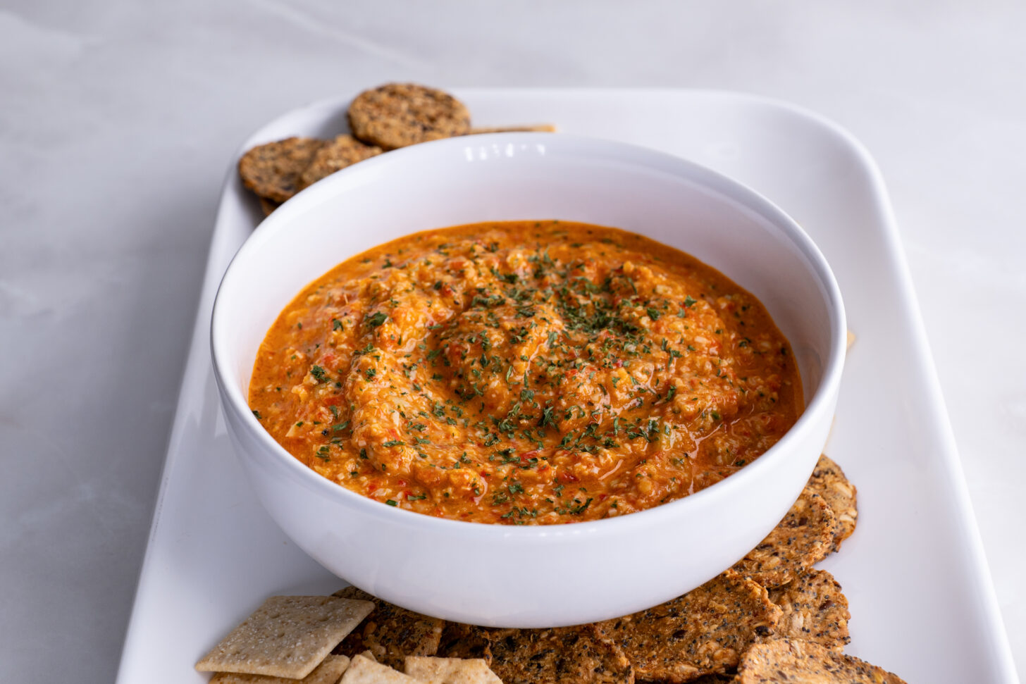 Roasted Red Pepper and Artichoke Dip surrounded with crackers