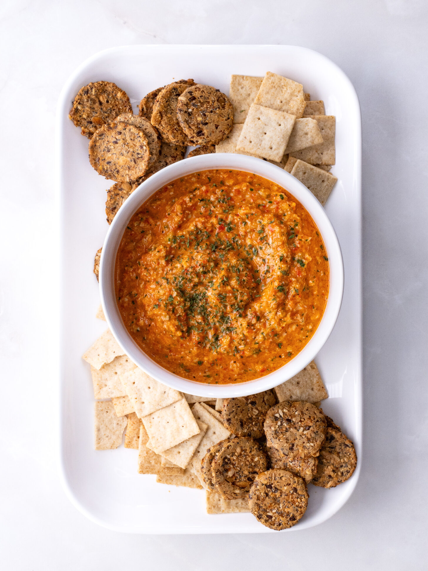 Roasted Red Pepper and Artichoke Dip surrounded with crackers
