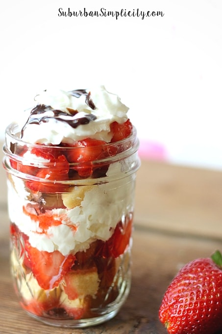 Strawberry Shortcake in a jar next to a fresh strawberry