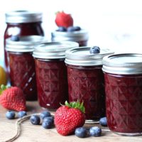 Mason jars Canned with Mixed Berry Jam. Strawberries and blueberries sound them.