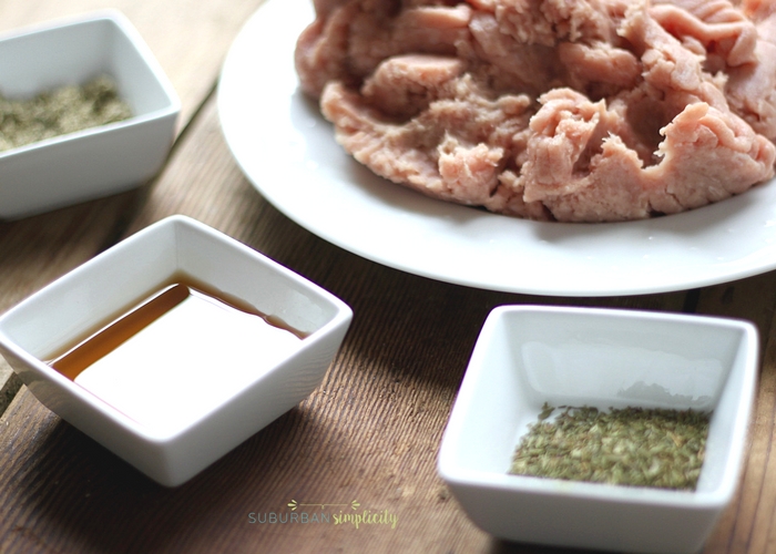 Ingredients including raw meat, maple syrup and dried herbs to make homemade maple sausage.