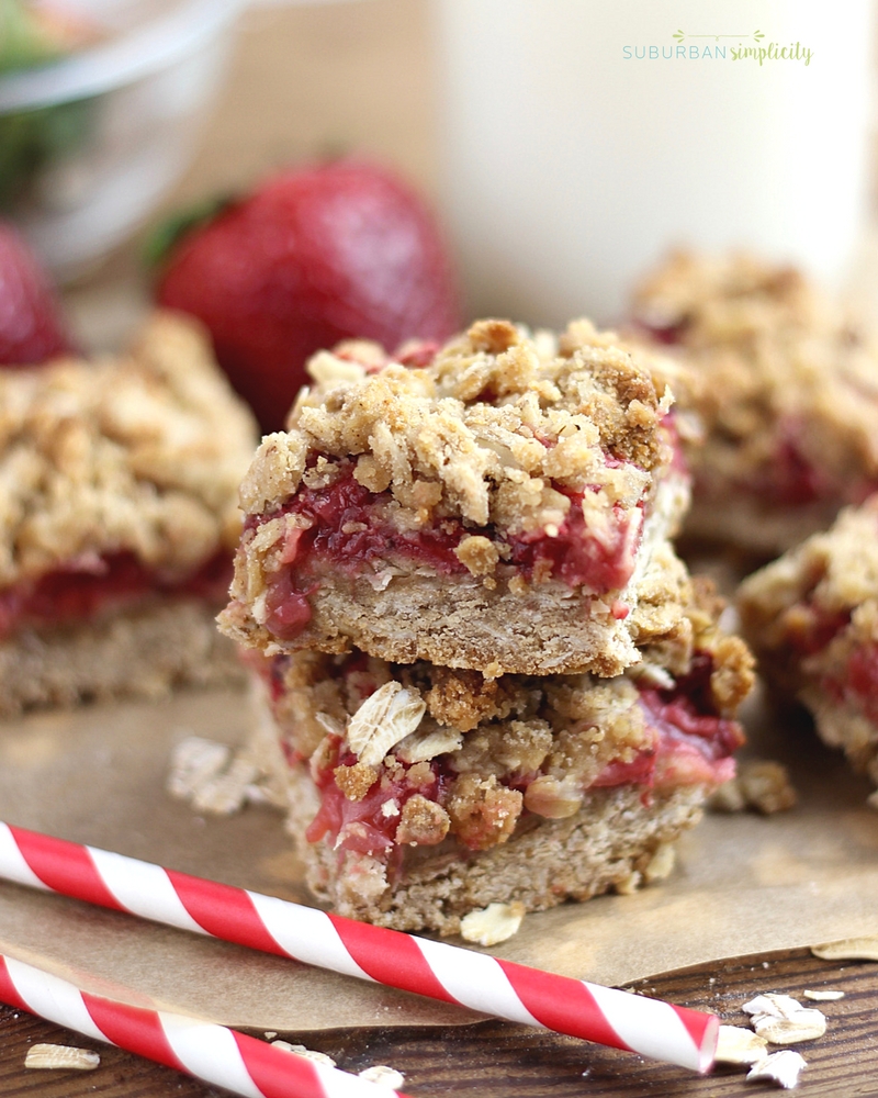 Easy Strawberry Oatmeal Bars filled with fresh strawberries stacked on parchment paper.