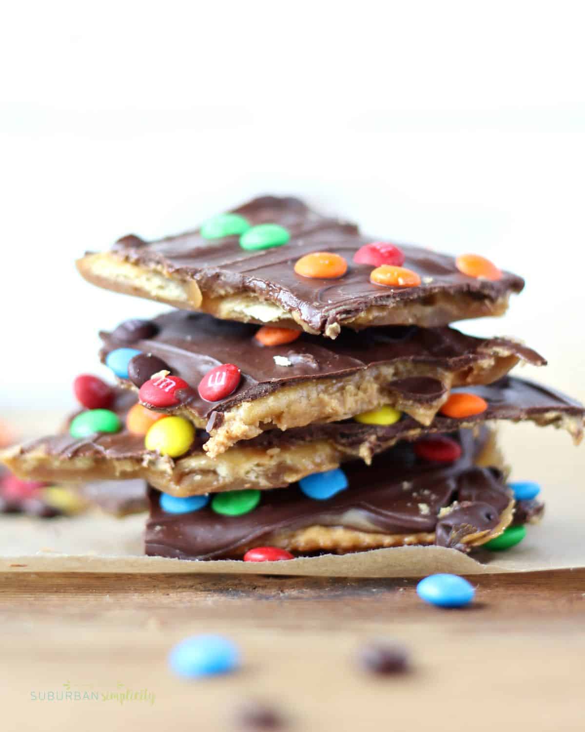 Five pieces of Saltine toffee with M&Ms stacked on each other.