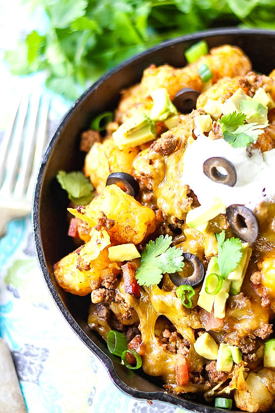 Loaded tater tot nachos with olives and cilantro.