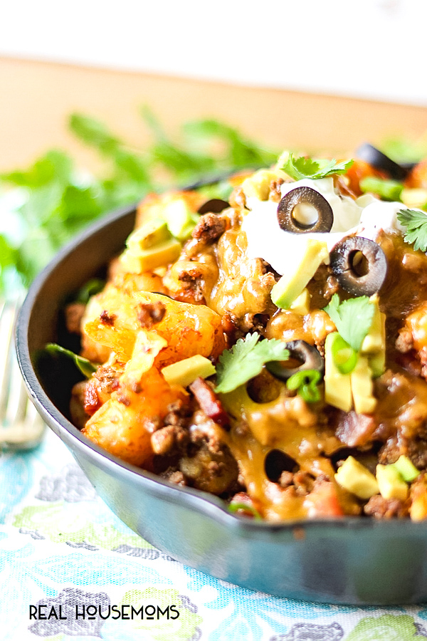 Enjoy the ultimate appetizer - Loaded Tater Tot Nachos! An irresistible recipe with crispy tots, melted cheese, meat and bacon that will have you coming back for seconds and thirds!