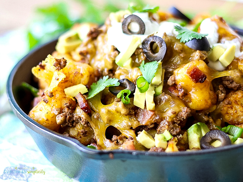 Loaded Tater tot Nachos in a cast iron pan.
