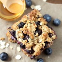 Blueberry oatmeal bar with honey next to it.