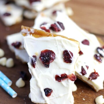 Cranberry Bliss Saltine Toffee is the best holiday treat idea! Crispy crackers, sweet caramel and melted white chocolate topped with tart cranberries. The perfect dessert combination! #cranberryblissrecipes #holidaydessert