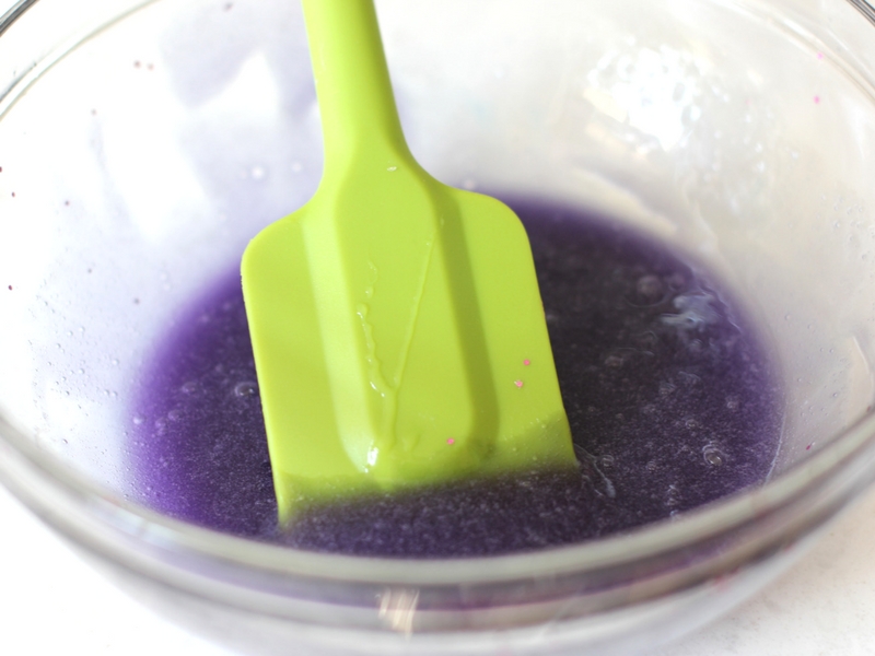 Glue, baking soda and food coloring in a bowl to make slime.