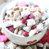 Valentine's Day puppy chow made from chex cereal in a bowl with a heart on it.