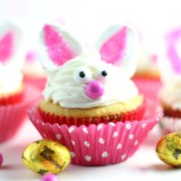Bunny Cupcakes with pink cupcakes liners and Butterfinger NestEgg candy next to them.