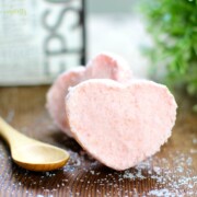 Pink heart shaped bath bombs with a spoon laying next to them.