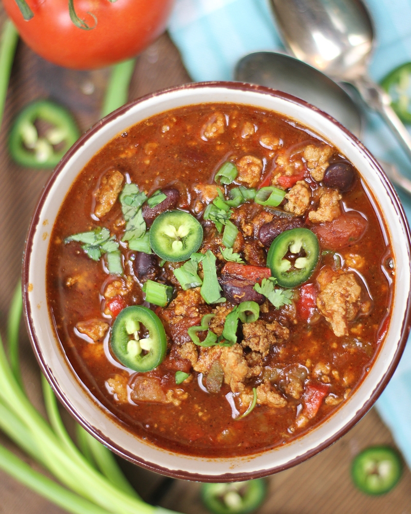 Healthy Crockpot Turkey Chili with jalapeño and green onion garnish