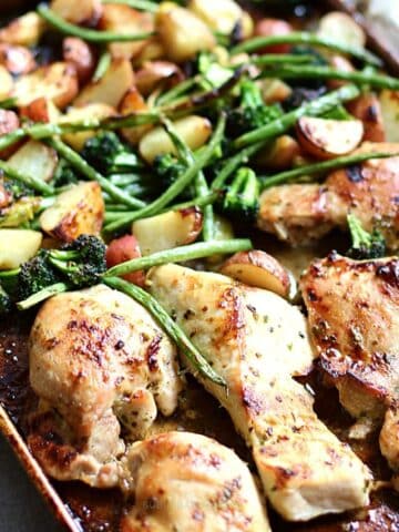 Baking tray with chicken in a honey garlic sauce with potatoes and vegetables.