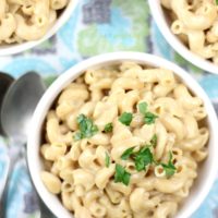 macaroni and cheese made in the instant pot in a bowl with garnish on top.