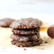 Healthy no bake cookies stacked with honey in the background.
