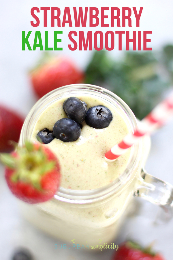 Delicious Strawberry Kale Smoothie in a mason jar with garnished with fresh strawberry and blueberries