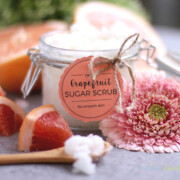 A freshly made jar of grapefruit sugar scrub with fresh grapefruit next to it.