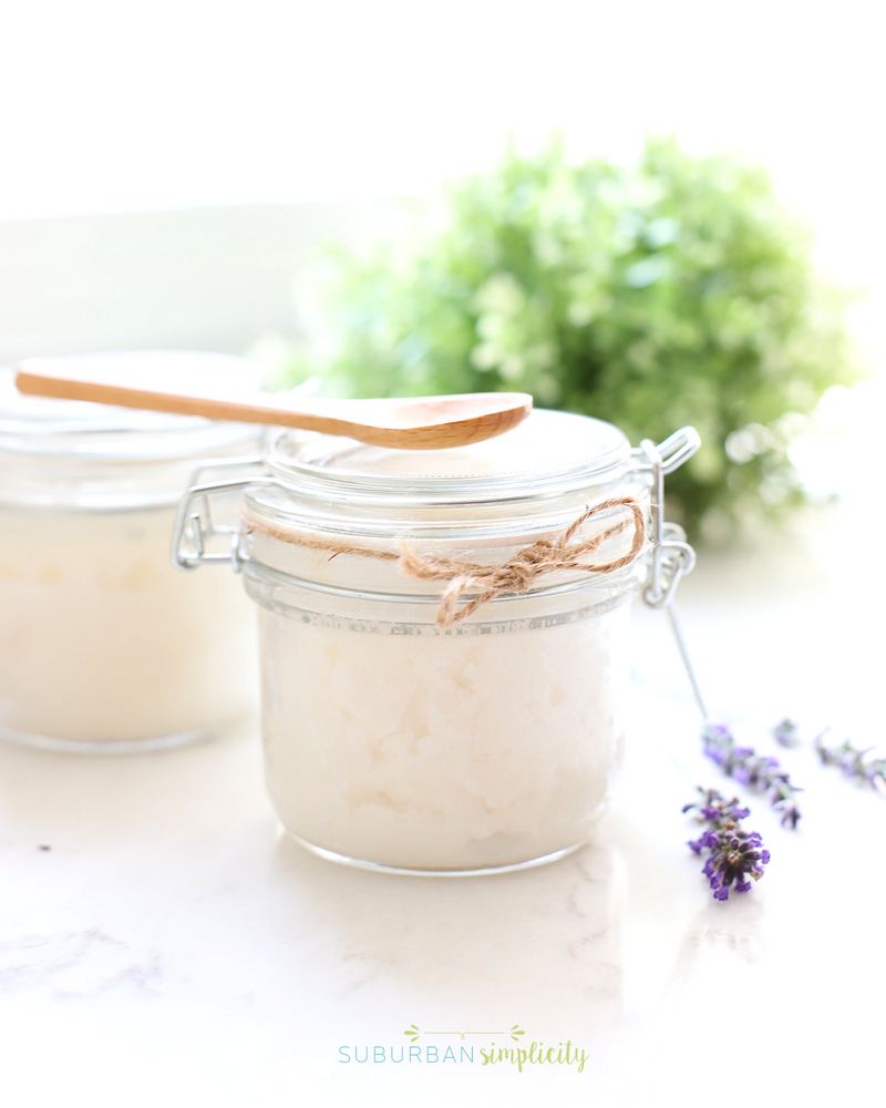 Jar of homemade sugar scrub with a wooden spoon on top.