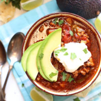Crock pot taco soup in a bowl with sour cream on top.