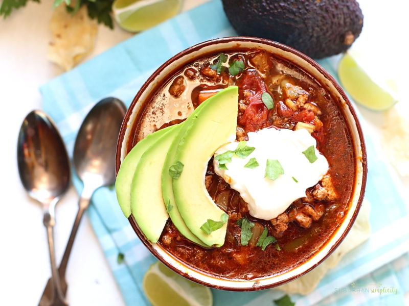 Crock pot taco soup in a bowl with sour cream on top.