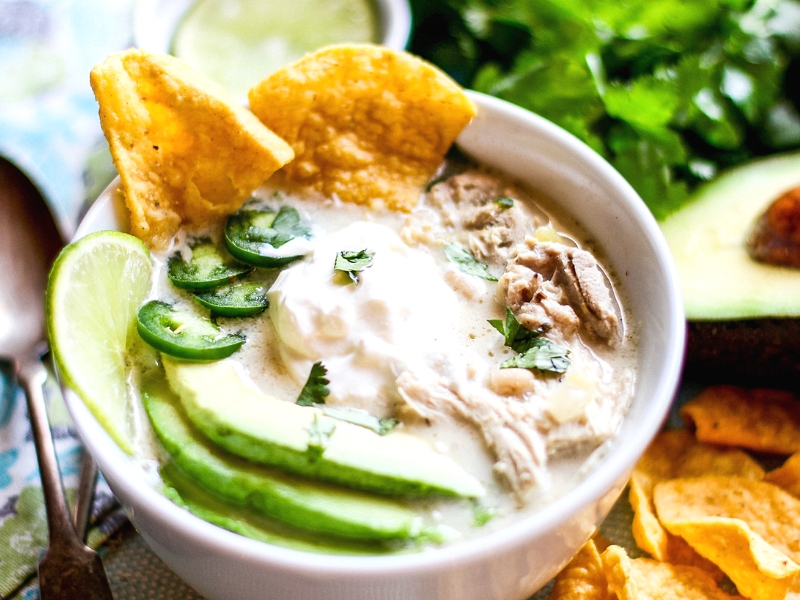 Crock Pot White Chicken Chili in a bowl topped with avocado and peppers