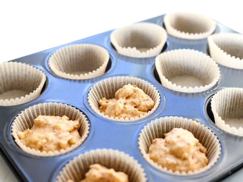 Batter for Banana Almond Butter Muffins in a pan with liners.