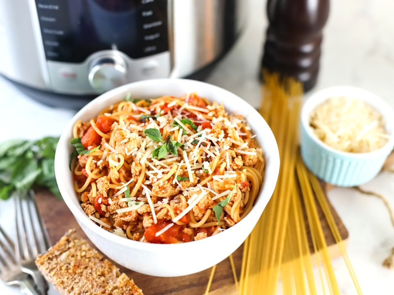 Instant Pot Spaghetti in a bowl with garlic bread.