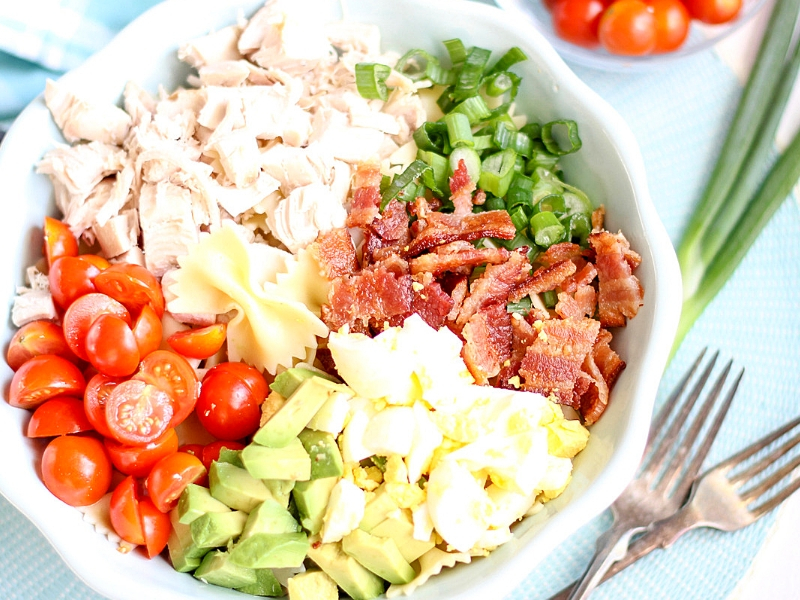 Ingredients for a Cobb Pasta Salad in a bowl.