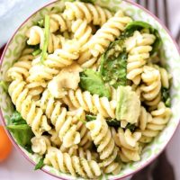 Close up photo of pesto pasta in a bowl.