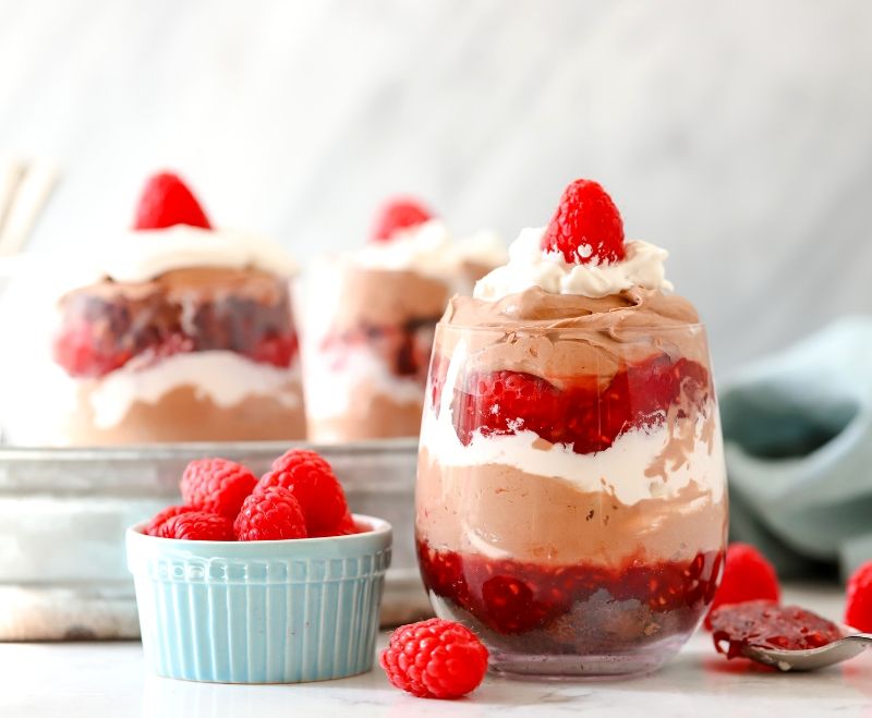 Raspberry Chocolate Mousse Trifle in a cup with raspberries next to it