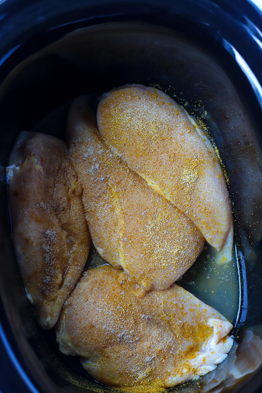 A close up of seasoned Chicken in a Crock Pot
