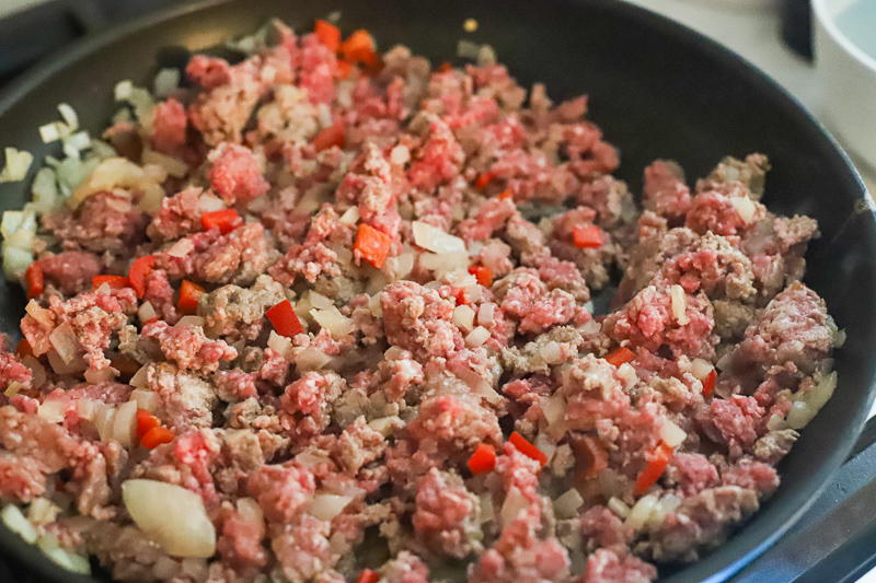 A pan filled with ground beef and onions.