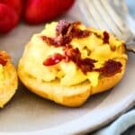 Breakfast Bagel on a plate topped with bacon.