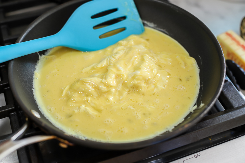 scrambled eggs cooking in a pan
