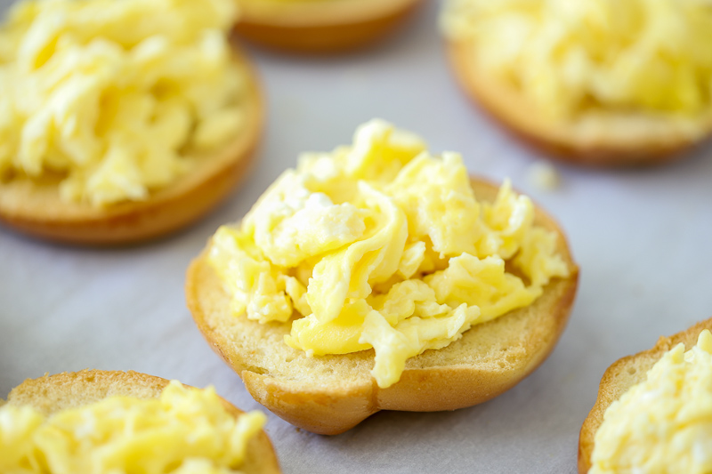 bagels topped with scrambled eggs