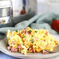 This easy Overnight Crock-Pot Breakfast Casserole is a delicious crowd-pleaser! Shredded potatoes are layered between savory ham, cheese, and eggs.