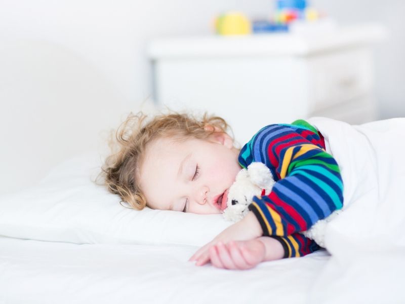 Toddler sleeping in bed.