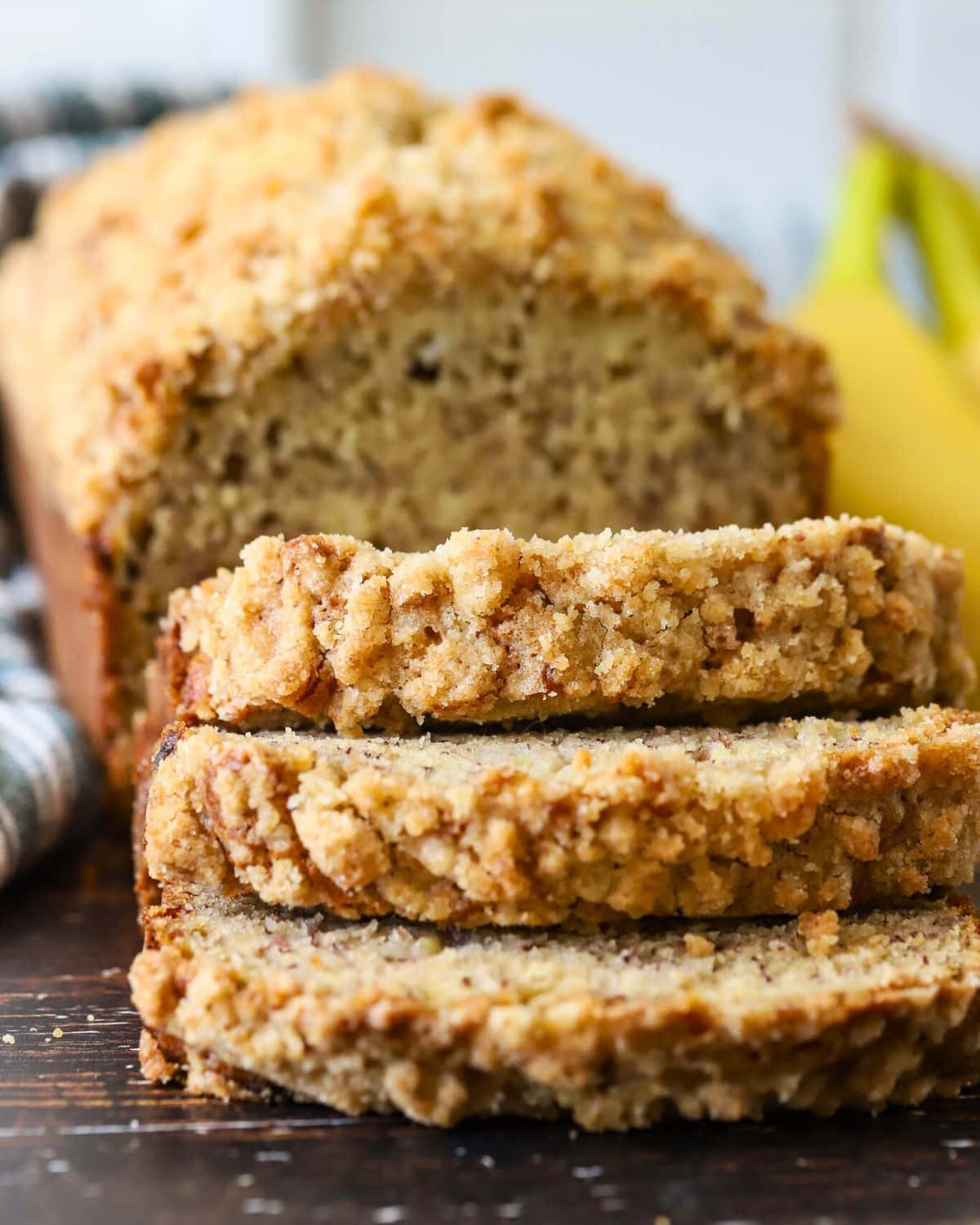 Banana bread topped with streusel cut into slices.