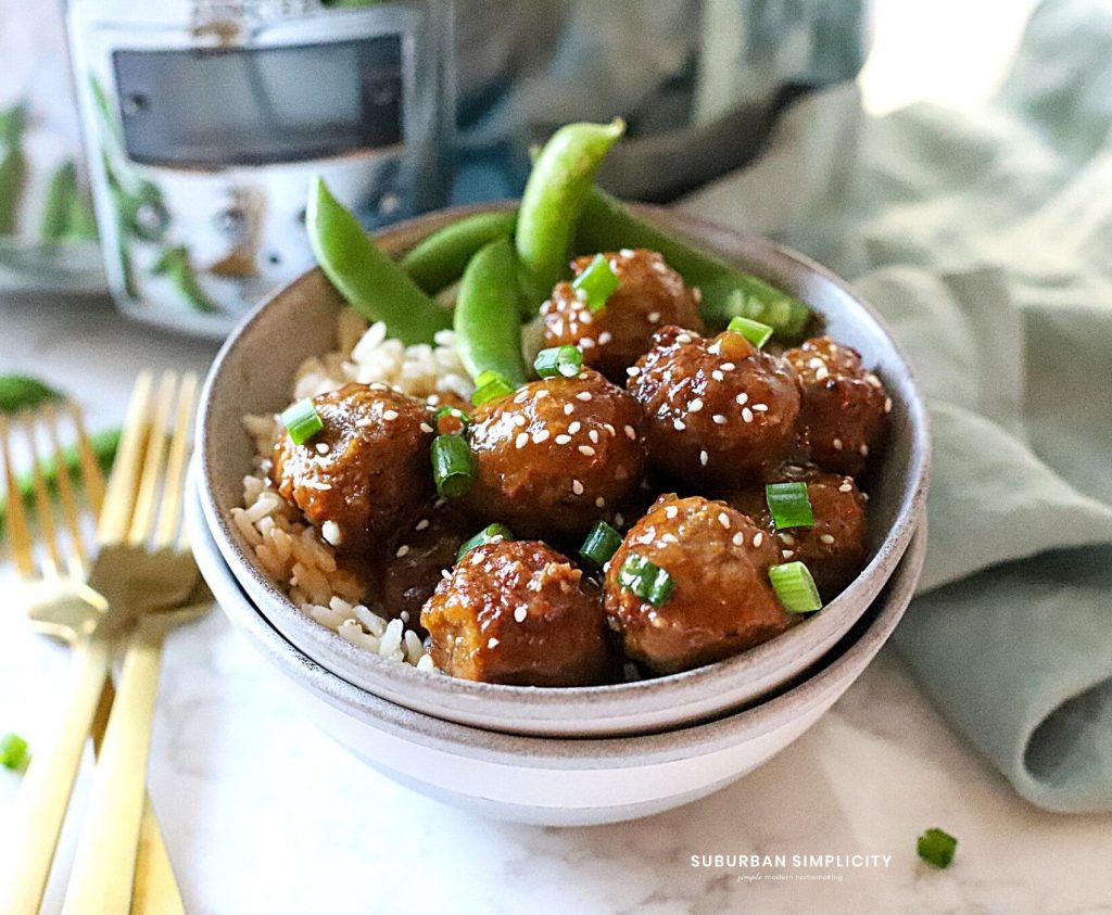 meatballs in a bowl with sesame seeds on top