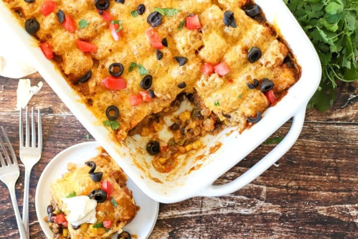 Tater tots taco casserole in a dish with a serving taken out.