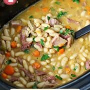 Ham and bean soup in a slow cooker with a ladle in it.