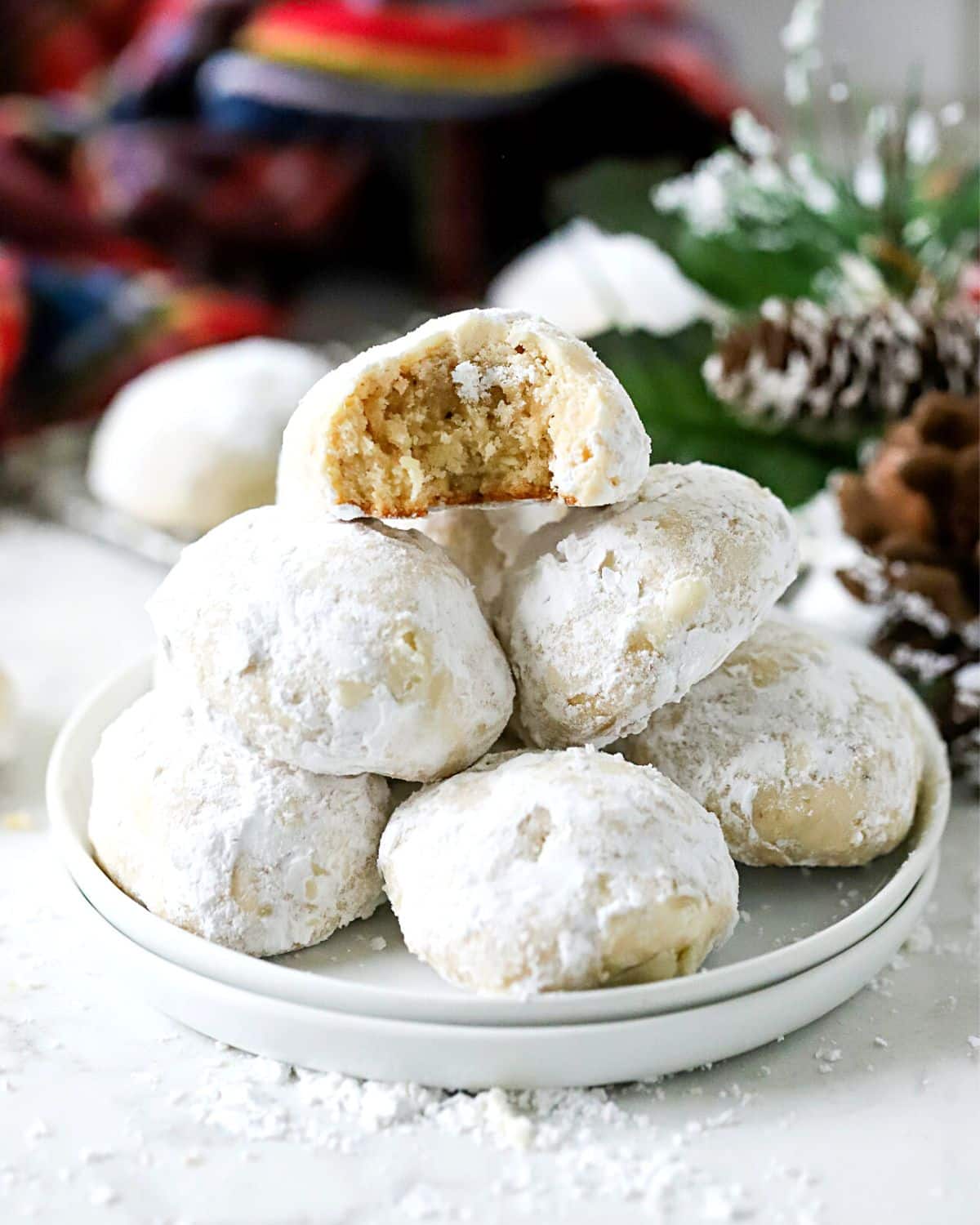 Snowball cookies stacked on a plate.