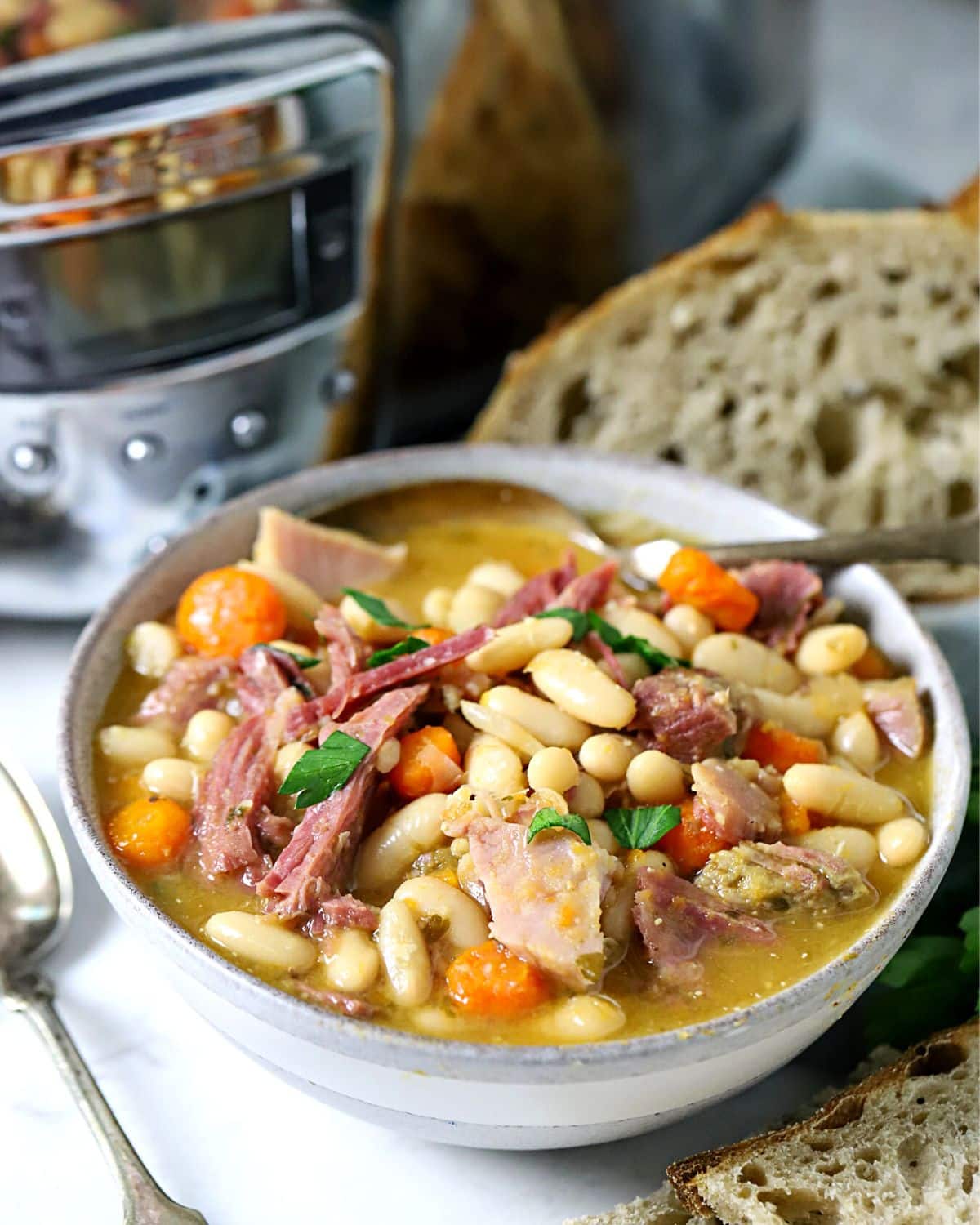 Crock pot bean soup in a bowl with a spoon in it.
