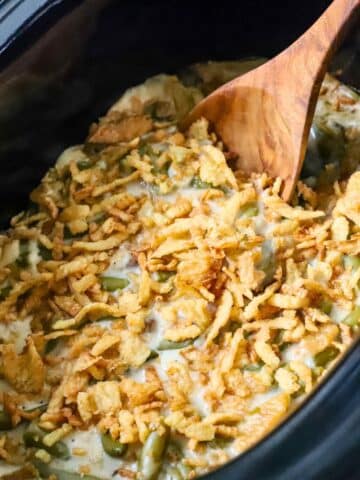 A crock pot green bean casserole freshly cooked.