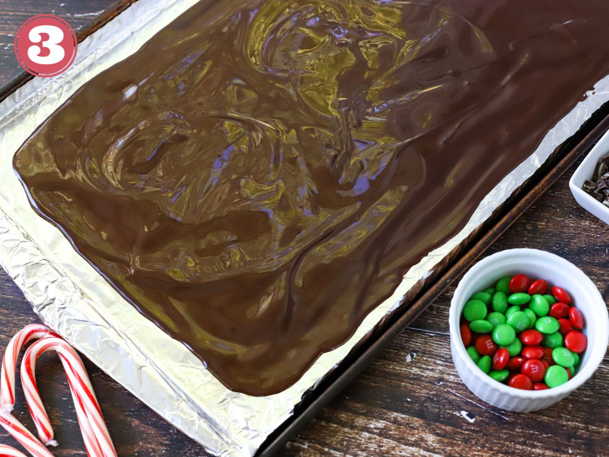 Melted chocolate on a baking pan lined with aluminum foil.